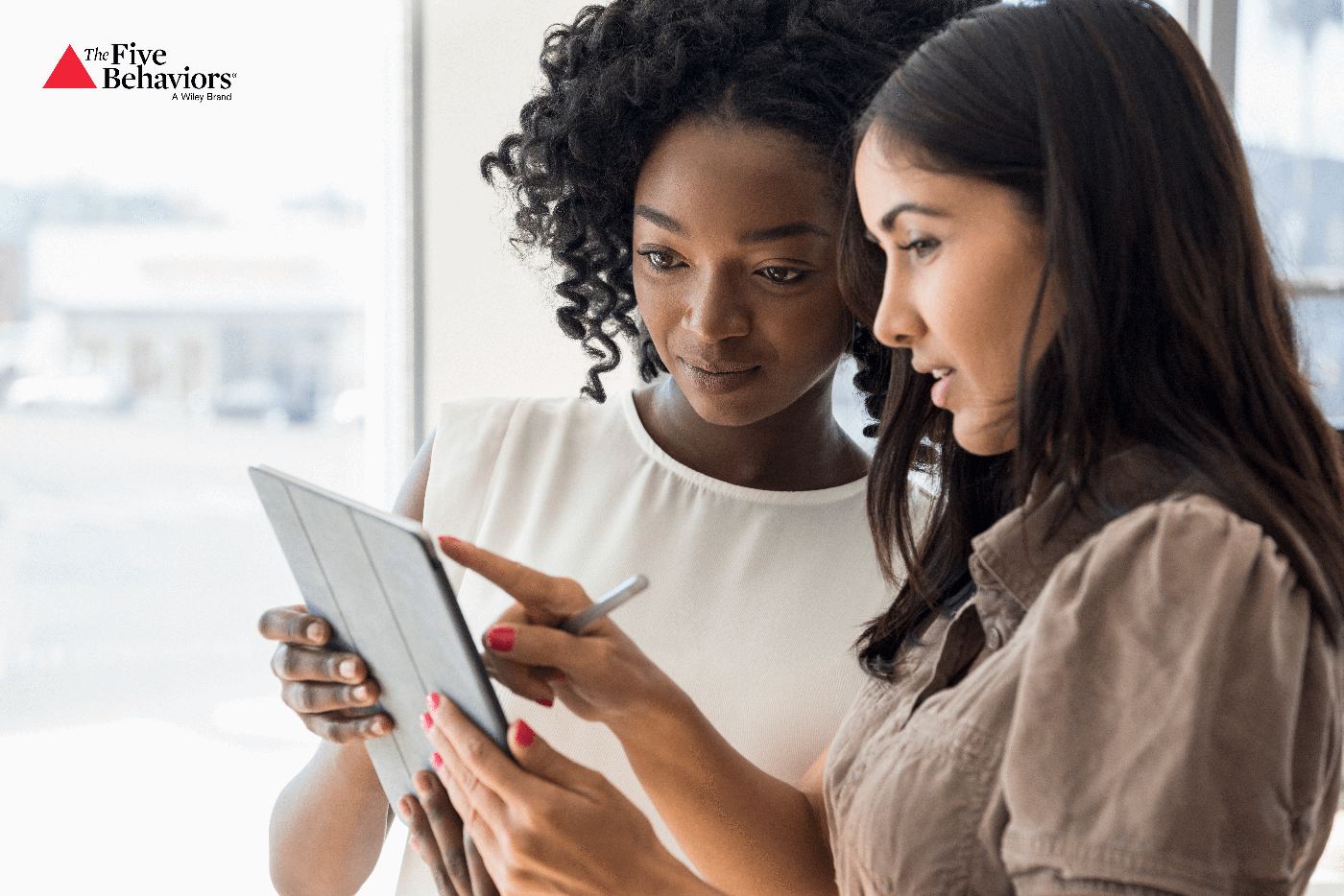 Two colleagues reviewing something together on a tablet