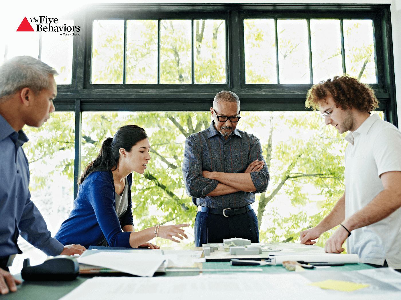 A team gathered around a table, discussing plans together