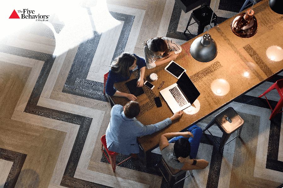 A team working together around a table with laptops and notes