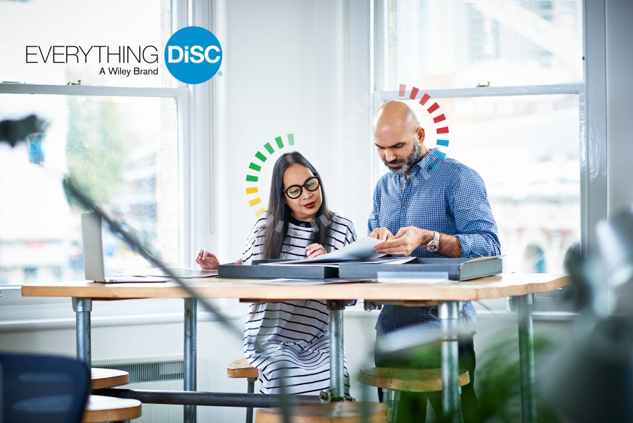 Two colleagues working through their Everything DiSC results together, each shown with a halo graphic in their own style colour